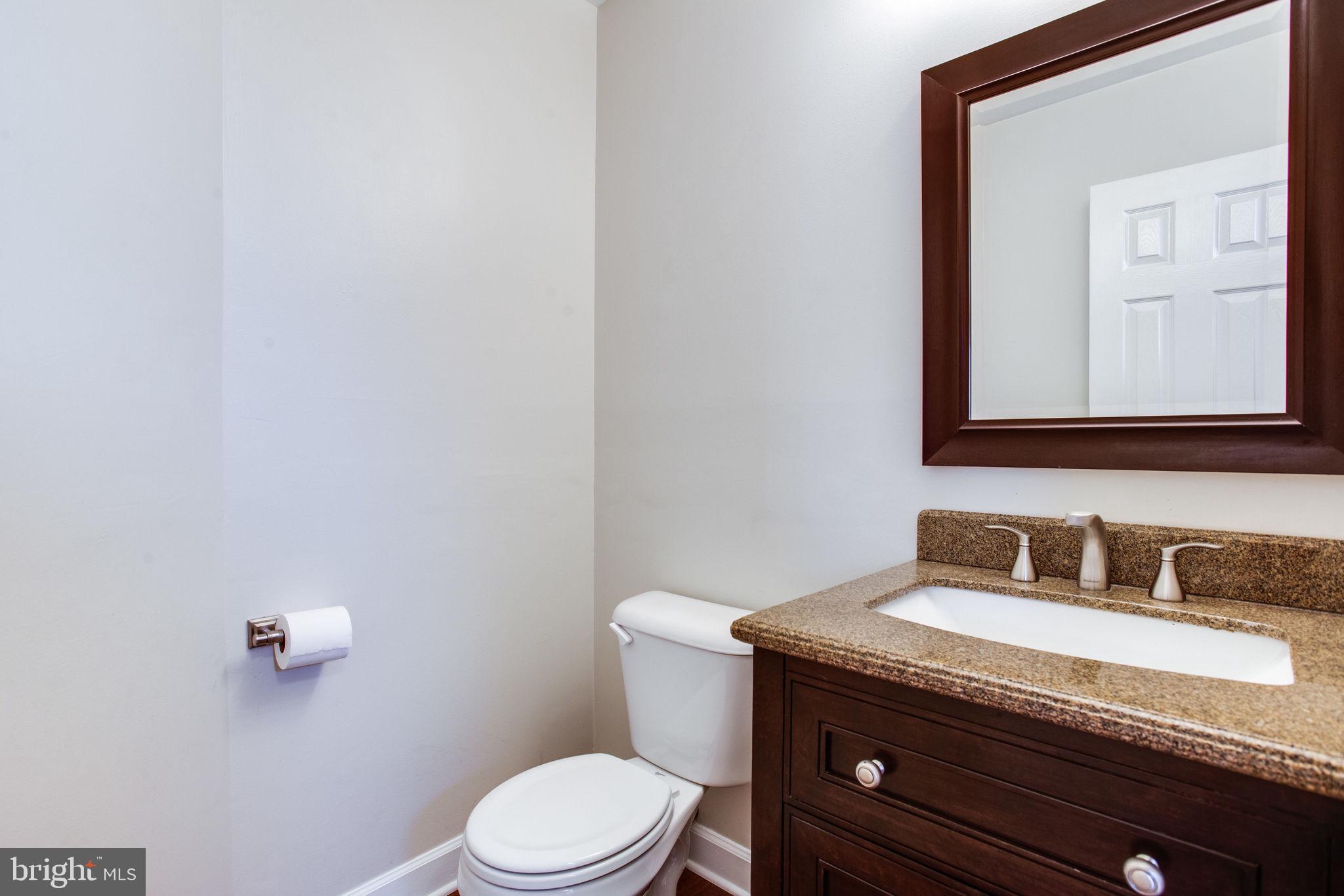 6121 Baldridge Circle Frederick, MD 21701 - Photo 26 of 60 a bathroom with a granite countertop toilet sink and mirror