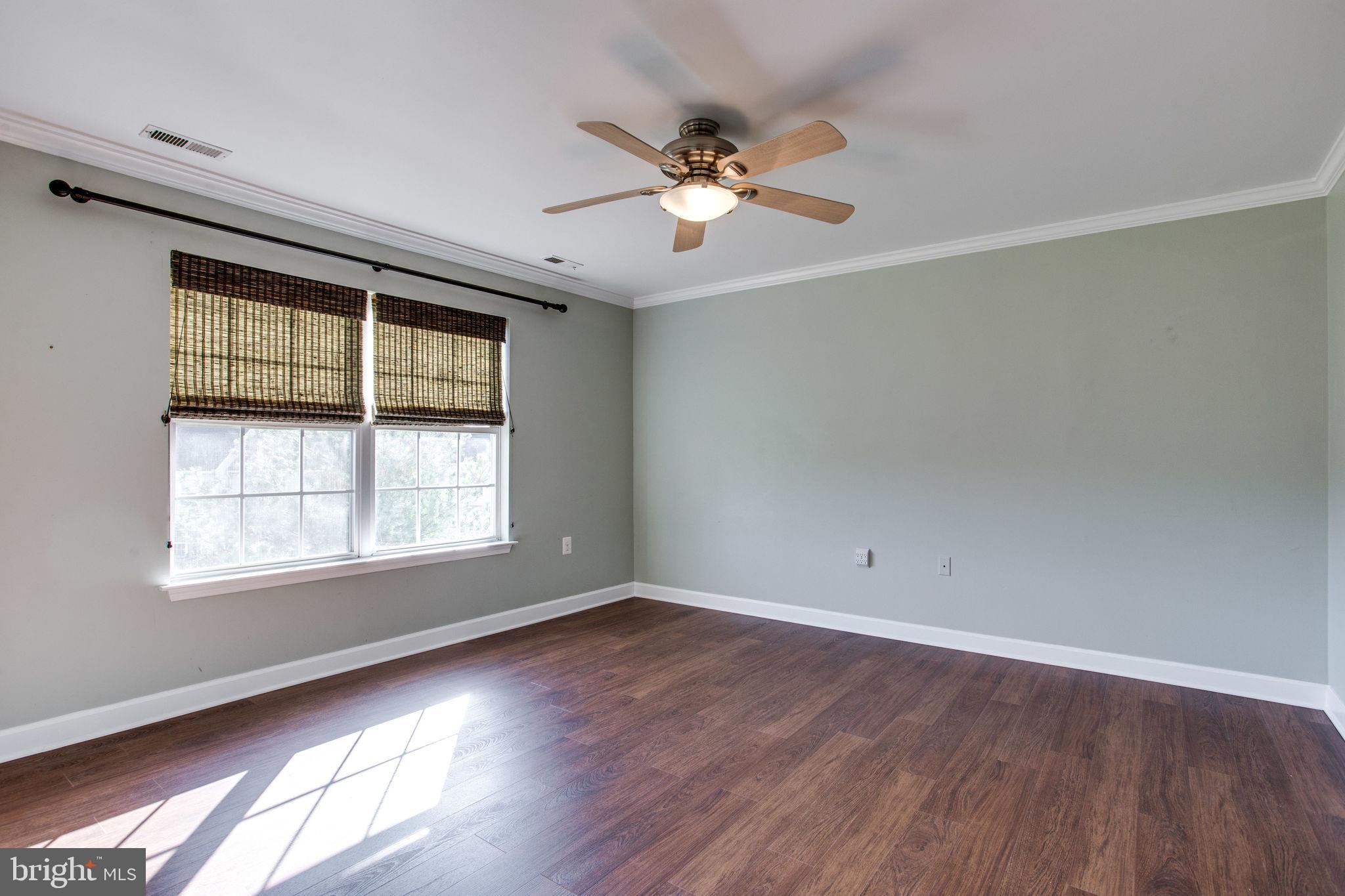 6121 Baldridge Circle Frederick, MD 21701 - Photo 28 of 60 an empty room with wooden floor fan and windows