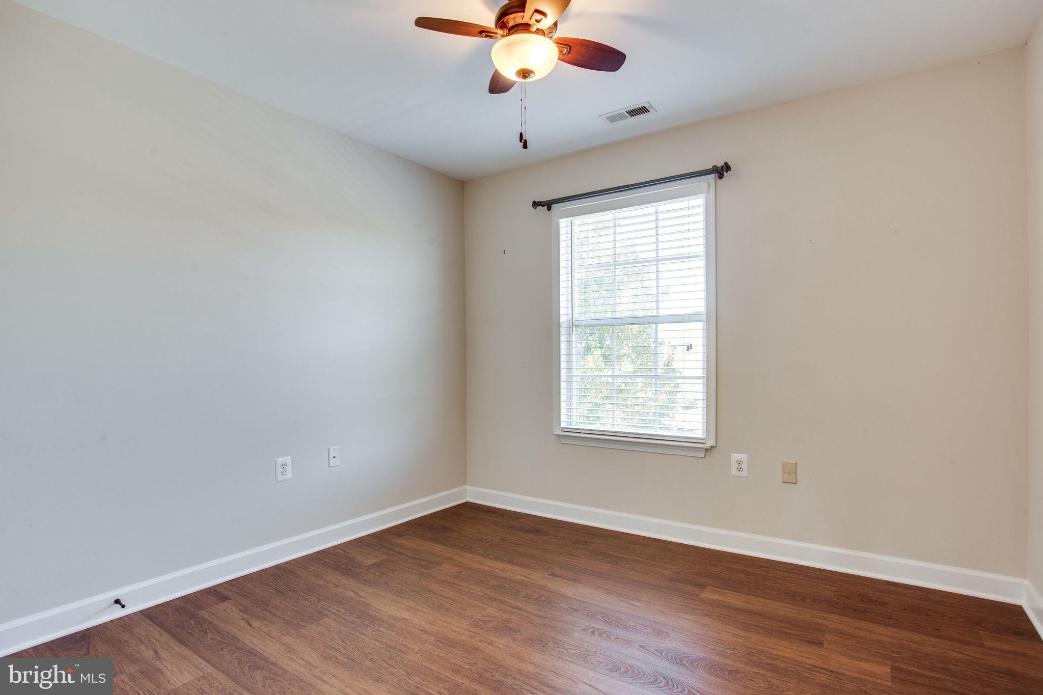 6121 Baldridge Circle Frederick, MD 21701 - Photo 41 of 60 an empty room with wooden floor chandelier fan and windows
