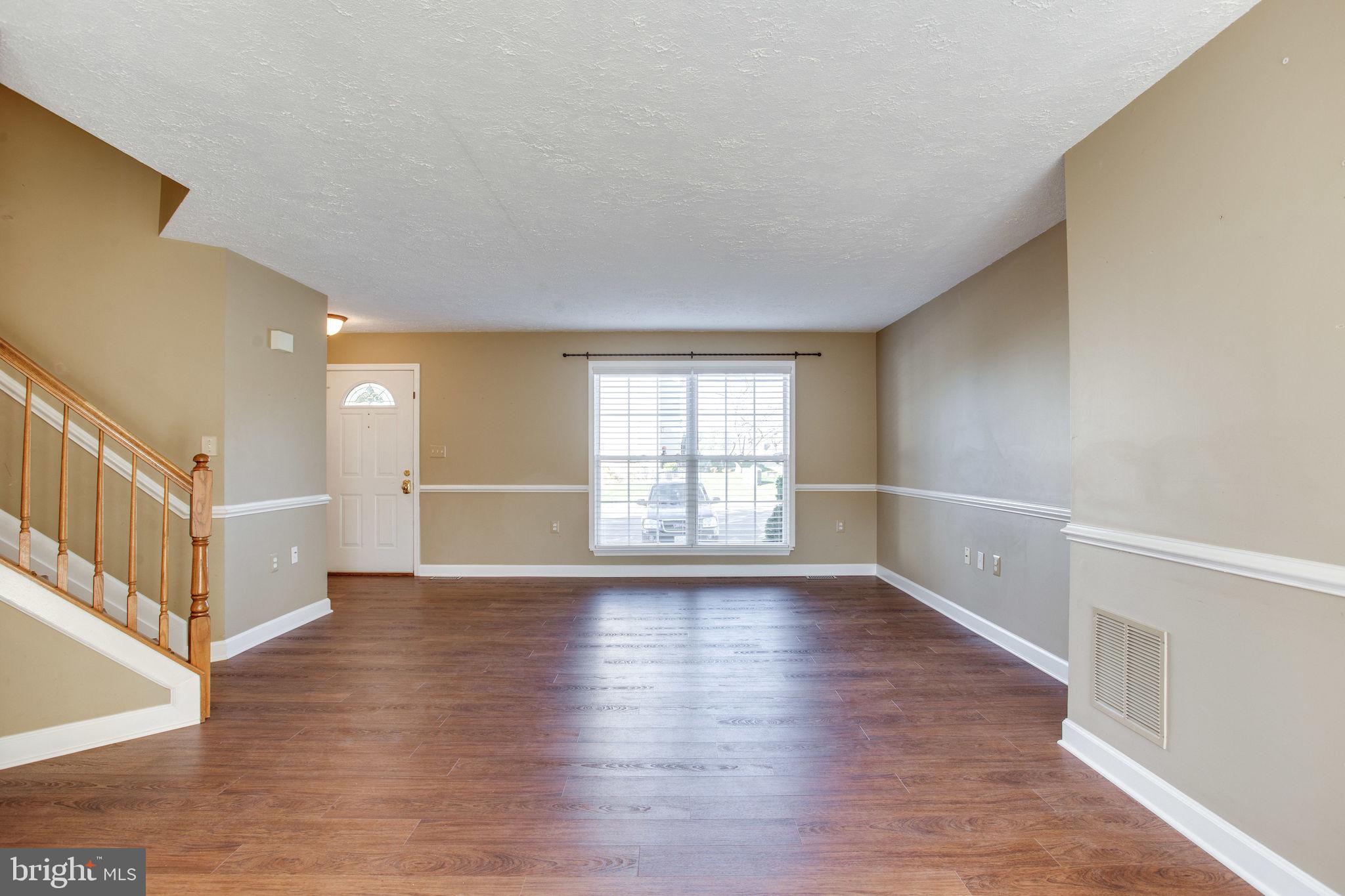 6121 Baldridge Circle Frederick, MD 21701 - Photo 7 of 60 a view of an empty room with wooden floor and a window