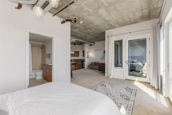 a bedroom with a large bed and a large mirror