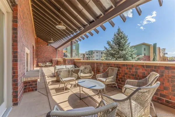 a view of a patio with a dining table and chairs with wooden floor