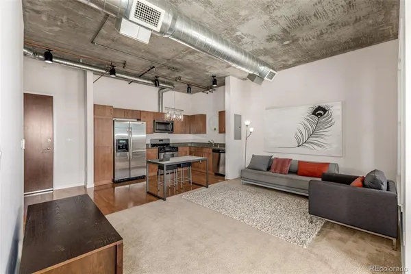 a living room with stainless steel appliances kitchen island granite countertop furniture and a kitchen view