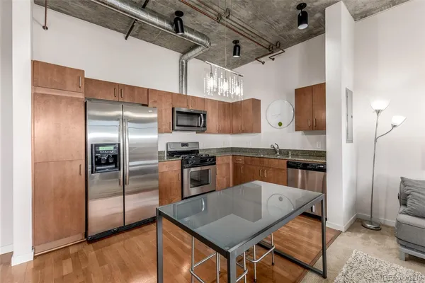 a kitchen with stainless steel appliances granite countertop a refrigerator a stove top oven a sink and dishwasher