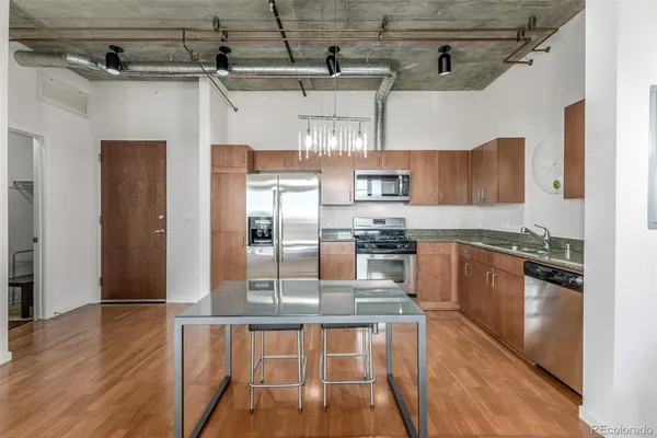 a kitchen with stainless steel appliances granite countertop a refrigerator and a stove top oven