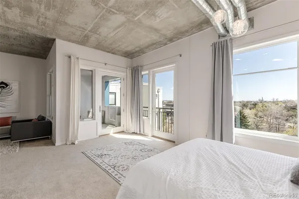 a bedroom with a bed and a large window