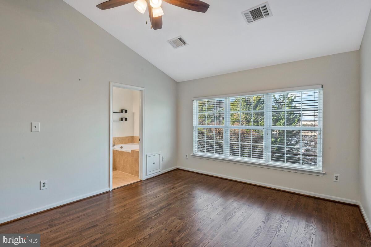 12025 Edgemere Circle Reston, VA 20190 - Photo 17 of 37 an empty room with wooden floor chandelier fan and windows
