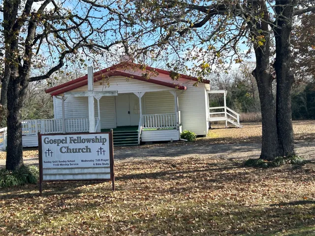 a view of a house with a tree next to a road