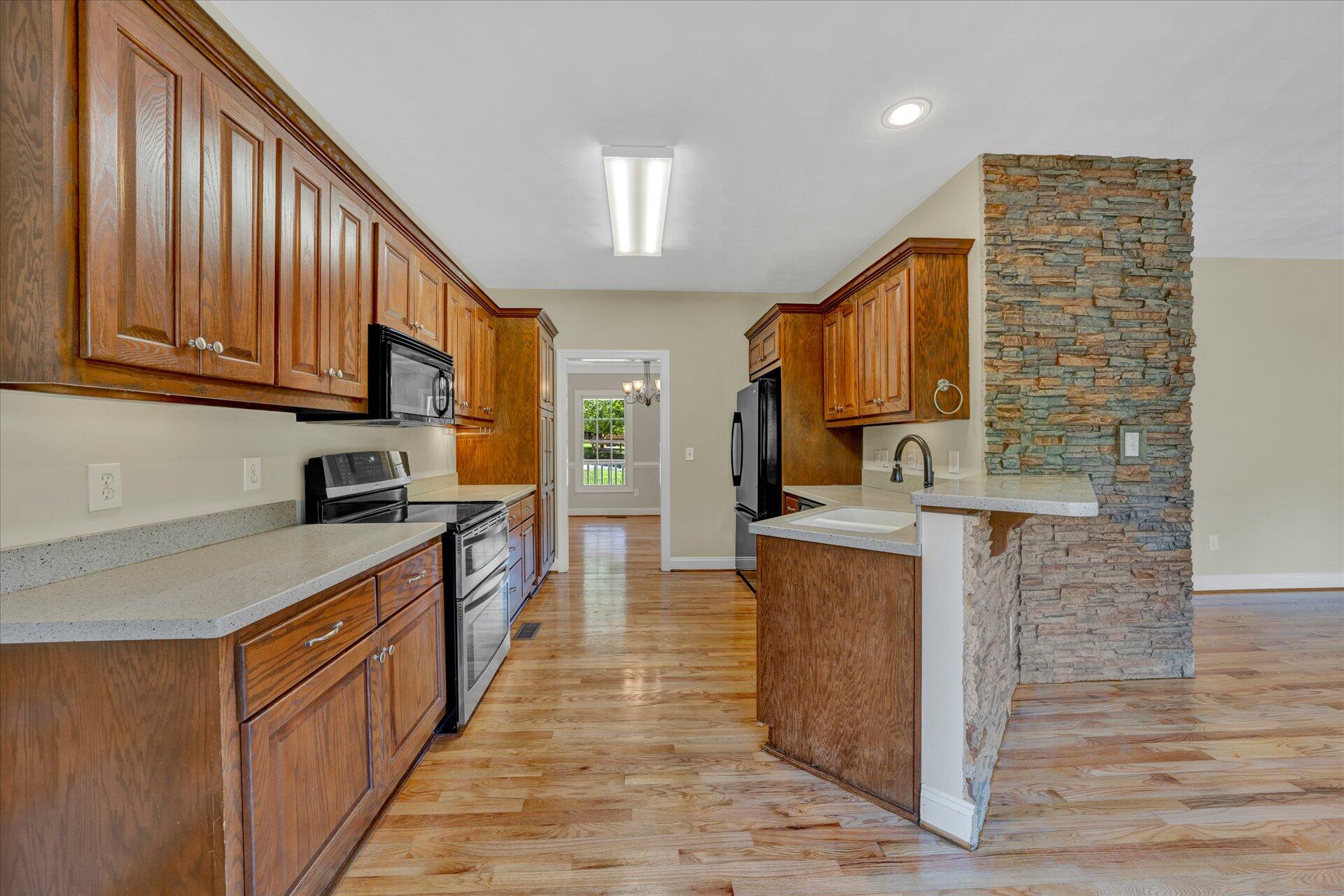 5295 Horseshoe Bend Road Goodview, VA 24095 - Photo 14 of 35 a kitchen with stainless steel appliances granite countertop lots of counter top space and wooden floor