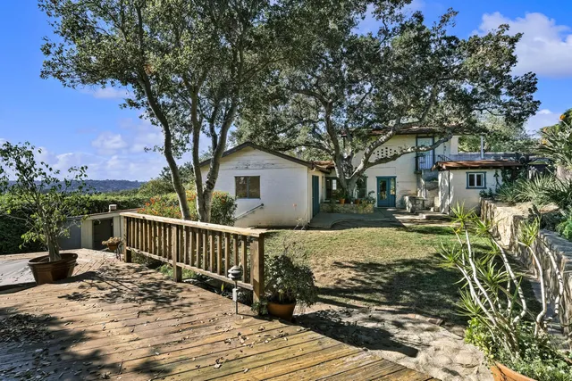 a view of a house with backyard and sitting area