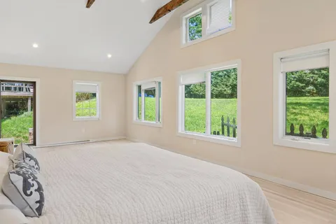 a view of a bedroom with a bed and a window