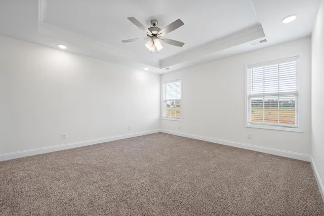an empty room with ceiling fan and window