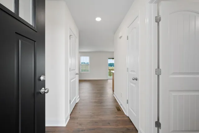 a view of a hallway with wooden floor and closet area