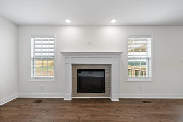 an empty room with fireplace and windows