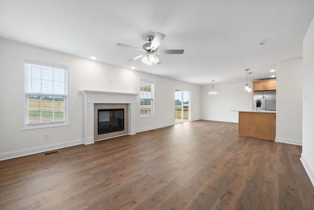 a view of an empty room with a fireplace and a window