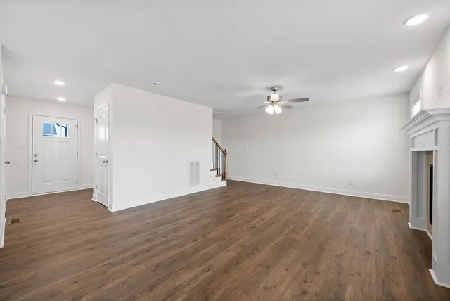 a view of a livingroom with wooden floor and a ceiling fan
