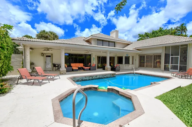 a view of a house with swimming pool and sitting area
