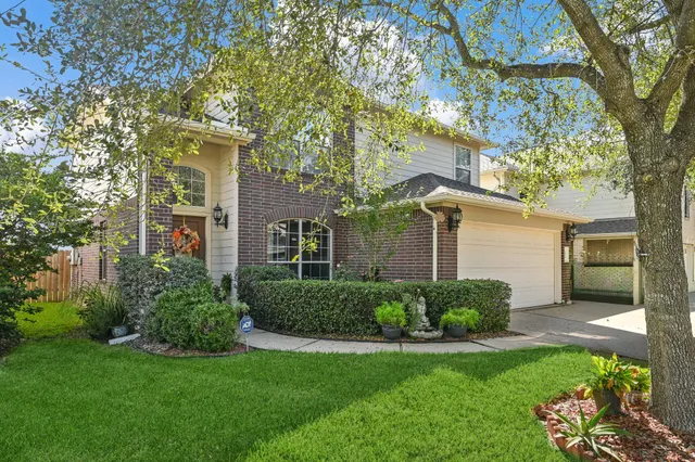 a front view of a house with a yard and potted plants
