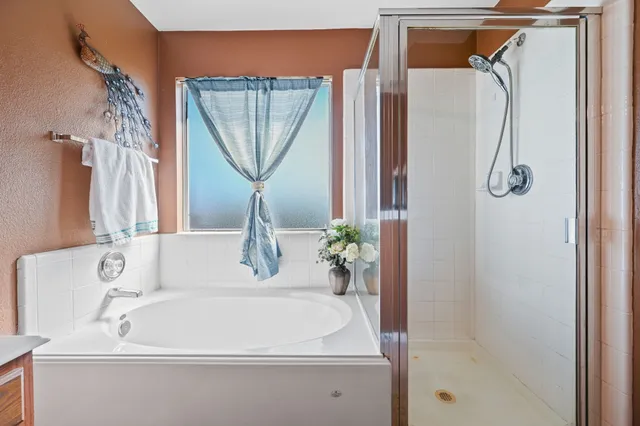 a white bath tub sitting next to a shower