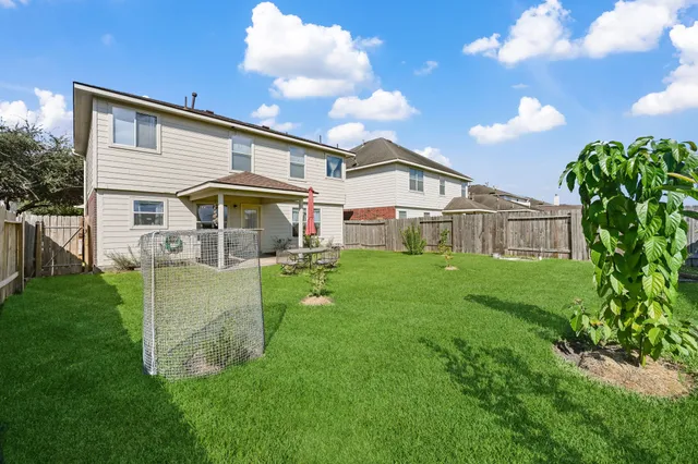 a front view of a house with a yard and large tree