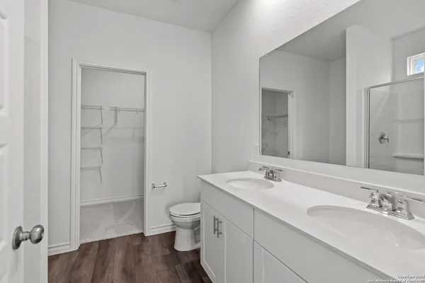 a bathroom with a granite countertop sink a toilet and a large mirror