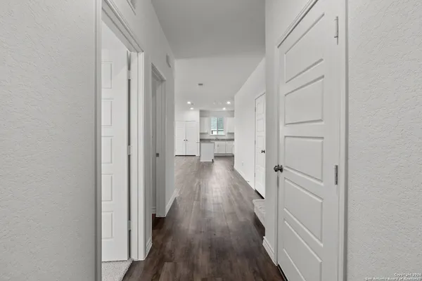 a view of a hallway with wooden floor