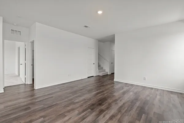 a view of an empty room with wooden floor