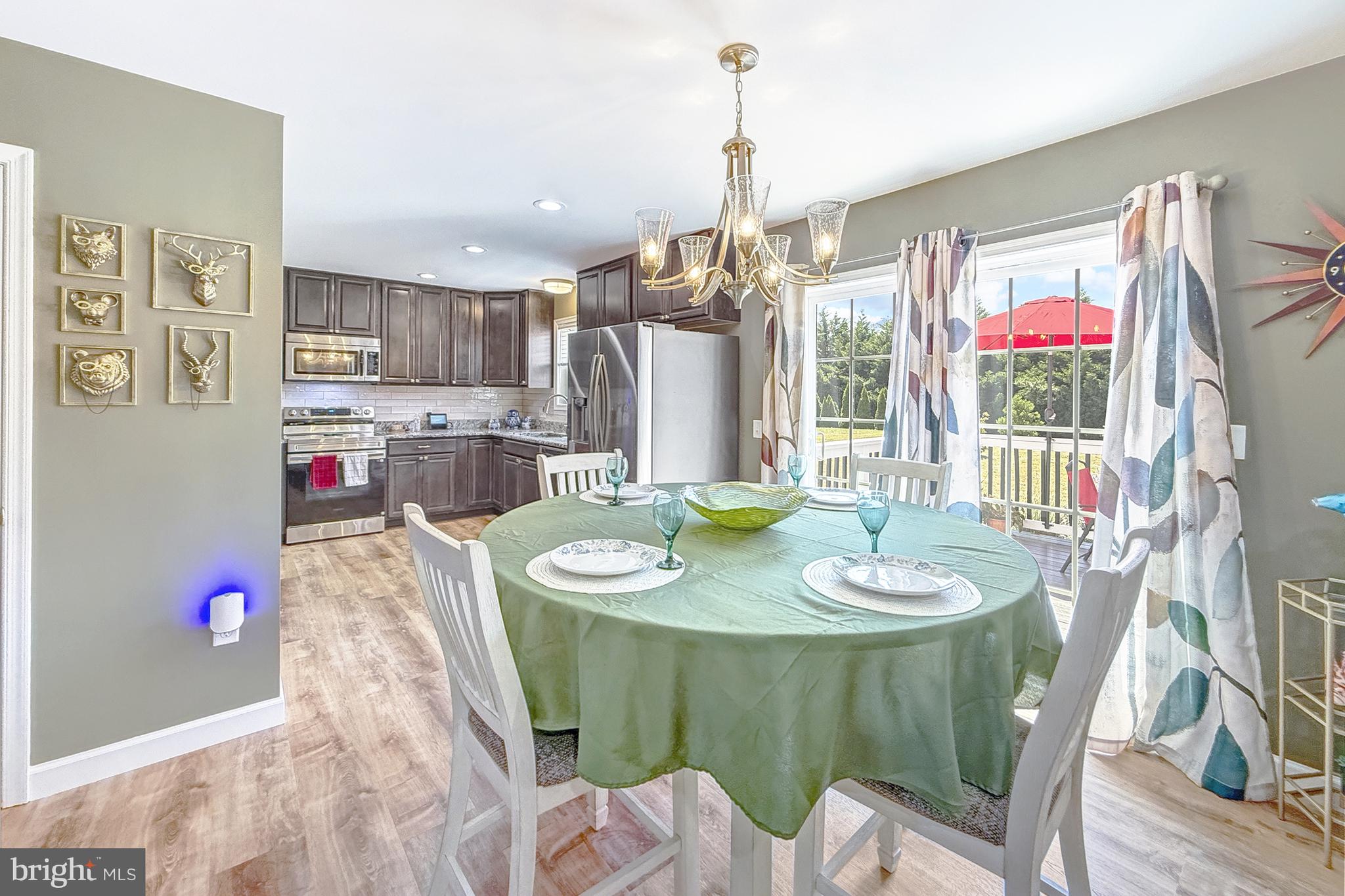 87 Trapper Lane Magnolia, DE 19962 - Photo 18 of 39 a dining room with kitchen island stainless steel appliances furniture a chandelier and a view of kitchen
