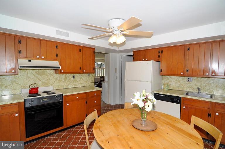 417 Waterford Road Silver Spring, MD 20901 - Photo 6 of 25 a kitchen with stainless steel appliances a sink a stove a dining table and chairs