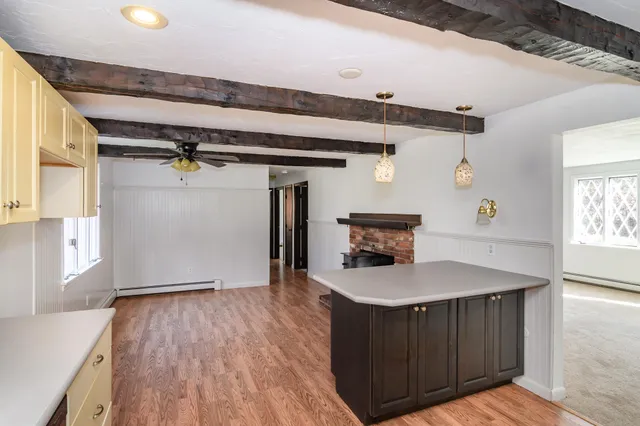 a kitchen with a wooden floor and cabinets