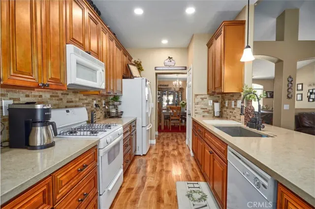 a kitchen with stainless steel appliances granite countertop a sink a stove and a refrigerator