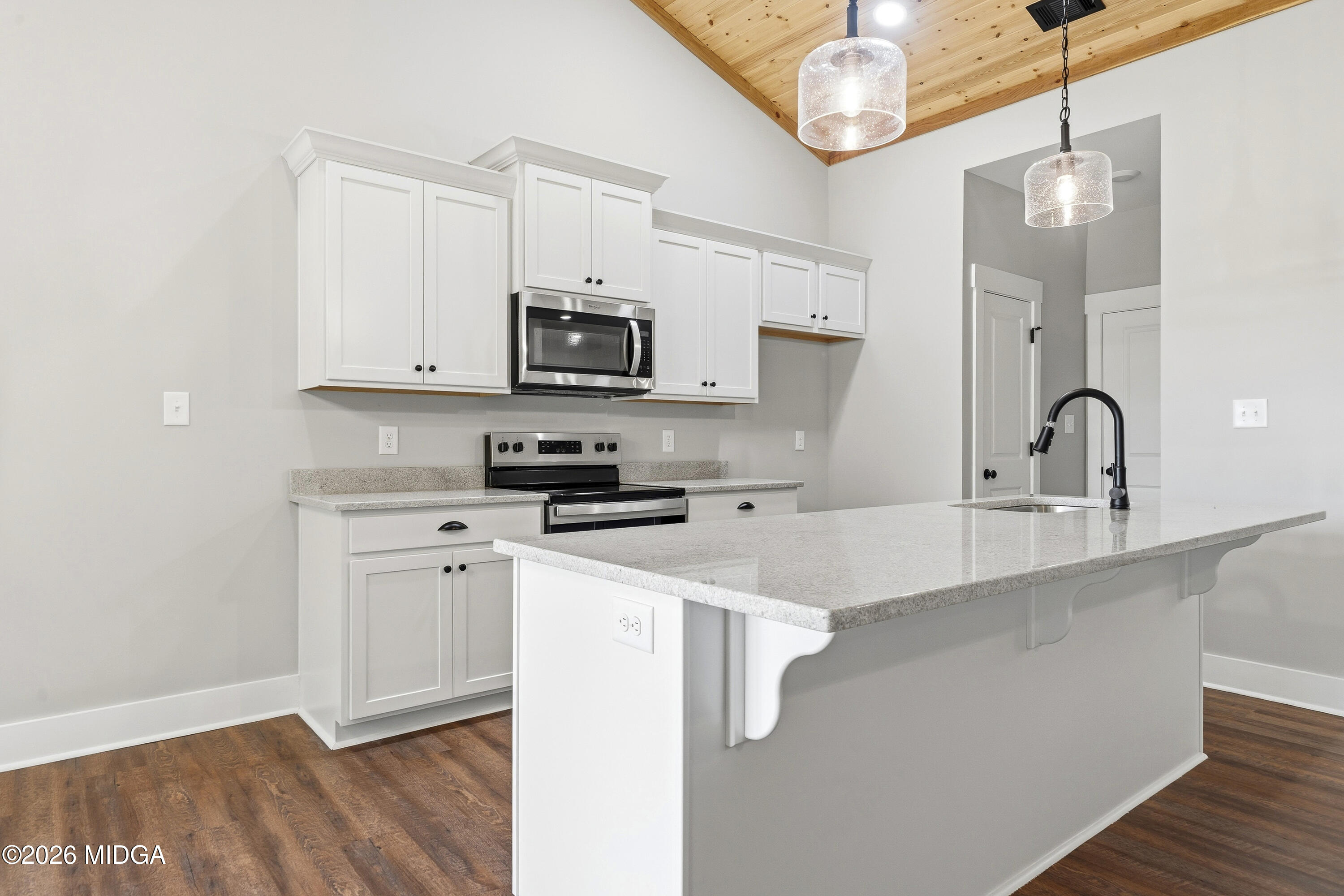146 Overland Way Gray, GA 31032 - Photo 11 of 38 a kitchen with stainless steel appliances a sink a stove a microwave a refrigerator cabinets and a wooden floor