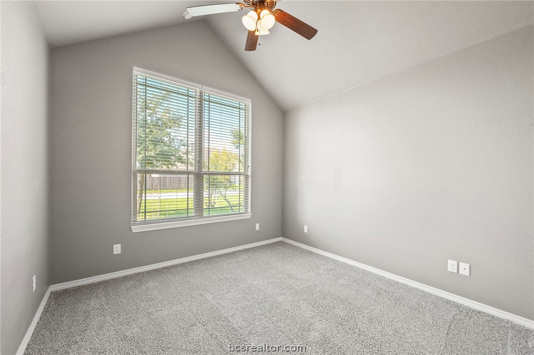 3028 Embers Loop Bryan, TX 77808 - Photo 15 of 26 Carpeted spare room with vaulted ceiling and a ceiling fan