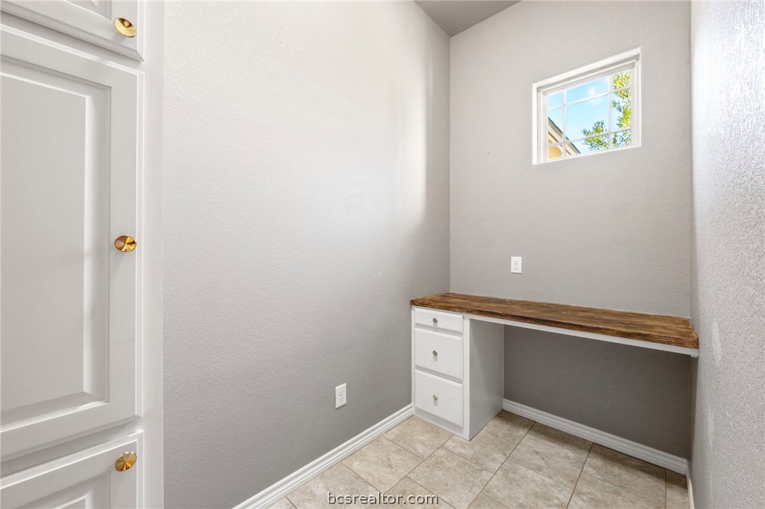 3028 Embers Loop Bryan, TX 77808 - Photo 20 of 26 Unfurnished office with built in study area, a textured wall, and light tile patterned floors