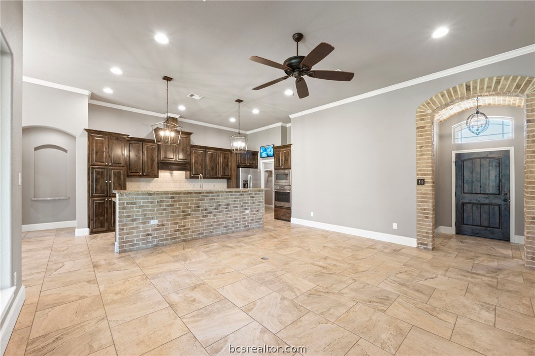 3028 Embers Loop Bryan, TX 77808 - Photo 3 of 26 Unfurnished living room with arched walkways, recessed lighting, crown molding, ceiling fan, and a chandelier