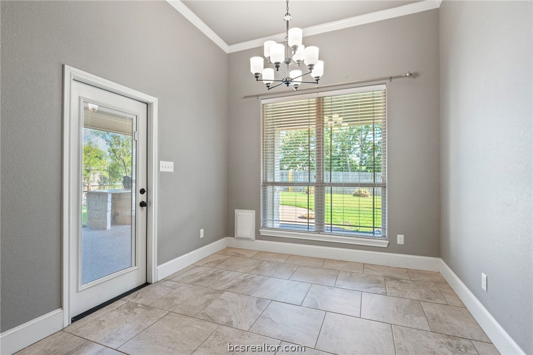 3028 Embers Loop Bryan, TX 77808 - Photo 8 of 26 Unfurnished dining area featuring ornamental molding and a chandelier