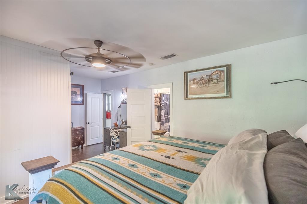202 East Ross Street Rising Star, TX 76471 - Photo 23 of 40 a bedroom with bed and a chandelier