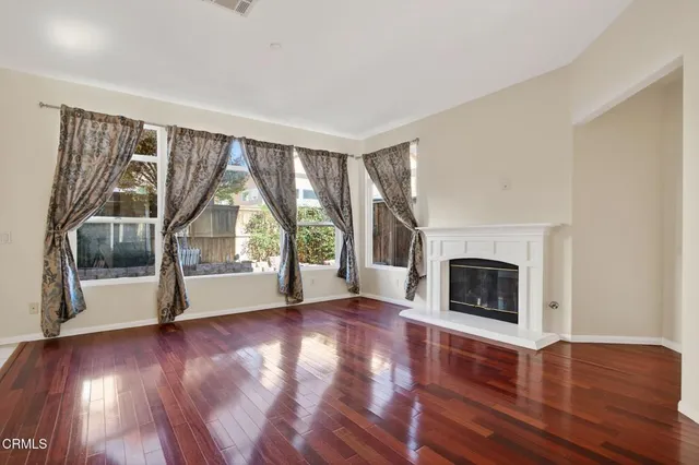 a view of a livingroom with furniture wooden floor and a kitchen