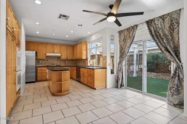 a kitchen with stainless steel appliances granite countertop a refrigerator and a sink