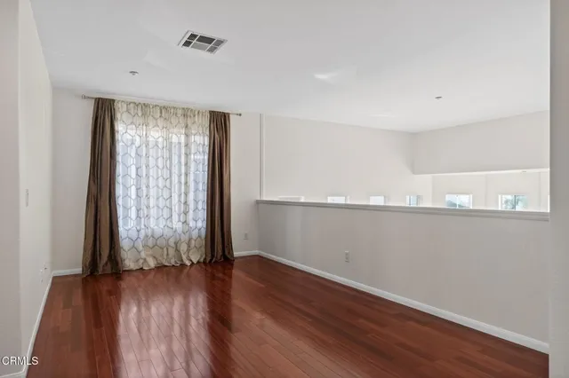 a view of a room with wooden floor and window