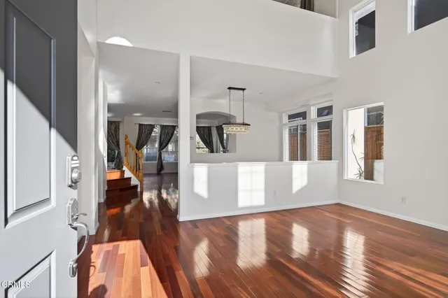 a view of an empty room with window and wooden floor
