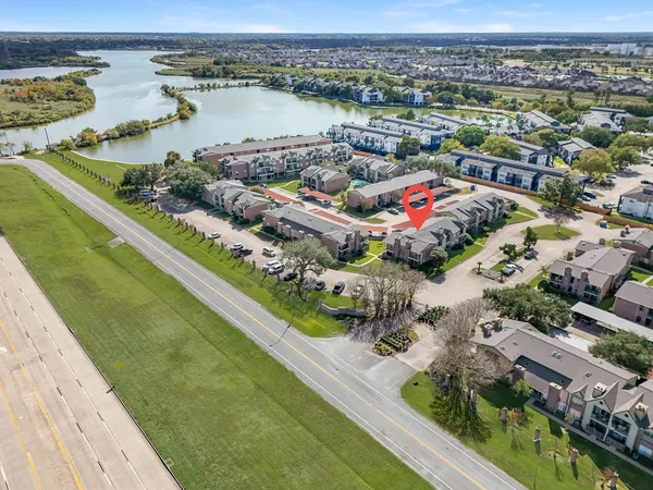 an aerial view of lake and residential houses with outdoor space