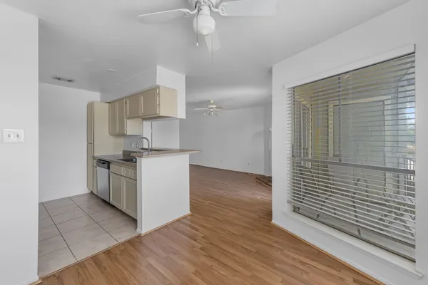 a kitchen with cabinets wooden floor and stainless steel appliances