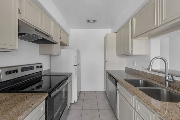 a kitchen with stainless steel appliances granite countertop a sink and cabinets