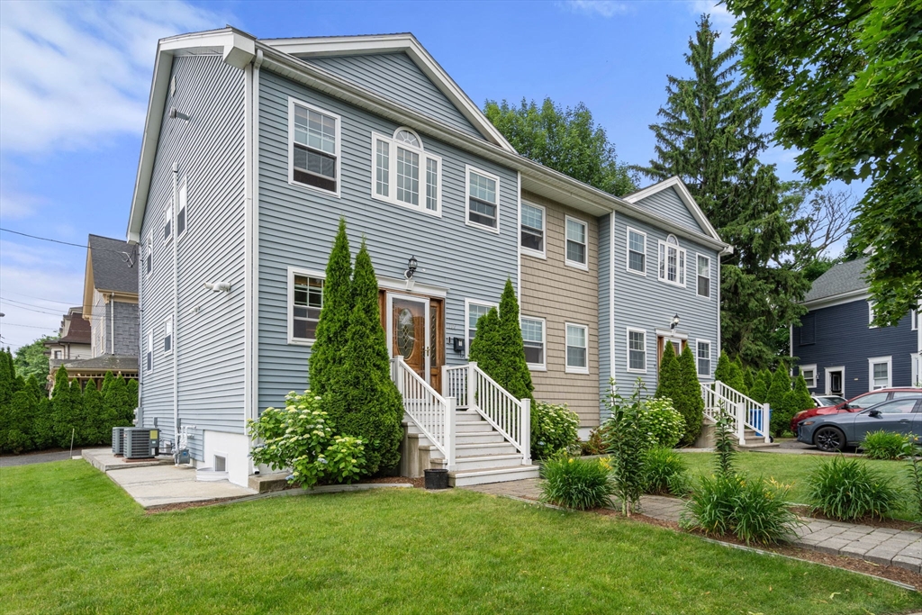 104 Crescent Street, Unit 1 Waltham, MA 02453 - Photo 1 of 30 a front view of a house with a yard