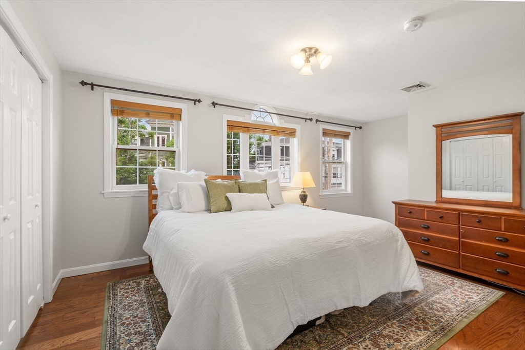 104 Crescent Street, Unit 1 Waltham, MA 02453 - Photo 12 of 30 a bedroom with a bed and wooden floor