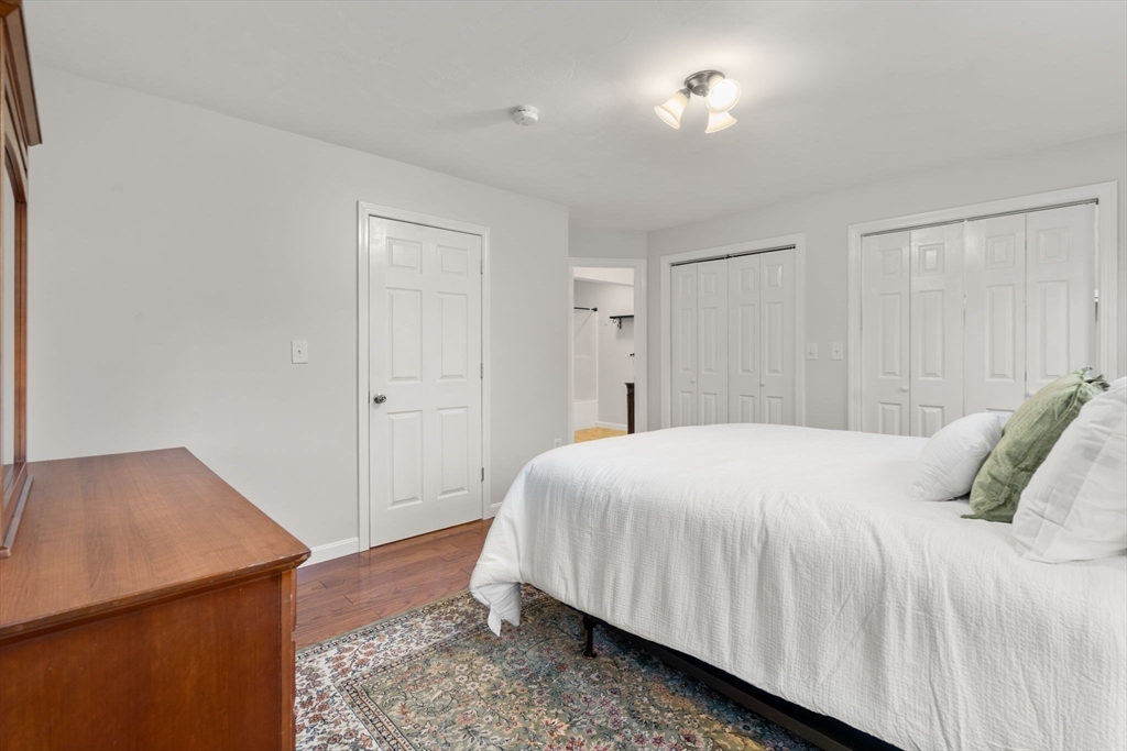 104 Crescent Street, Unit 1 Waltham, MA 02453 - Photo 13 of 30 a bedroom with a bed and wooden floor