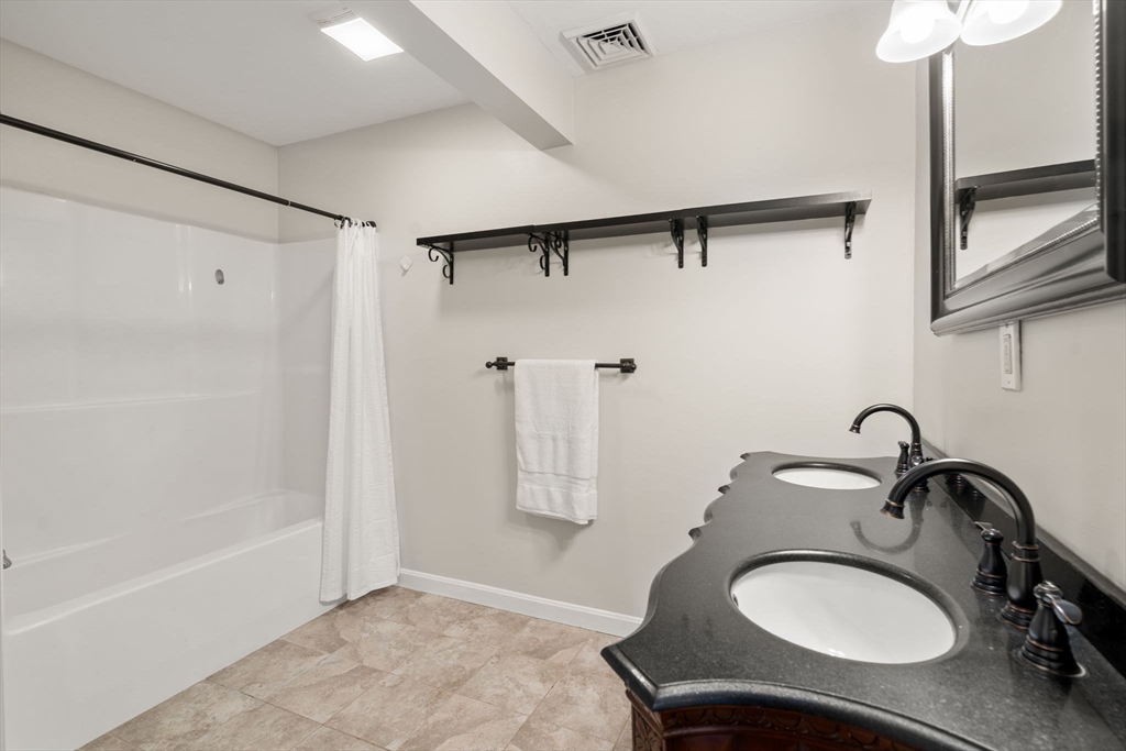 104 Crescent Street, Unit 1 Waltham, MA 02453 - Photo 16 of 30 a bathroom with a sink and a mirror