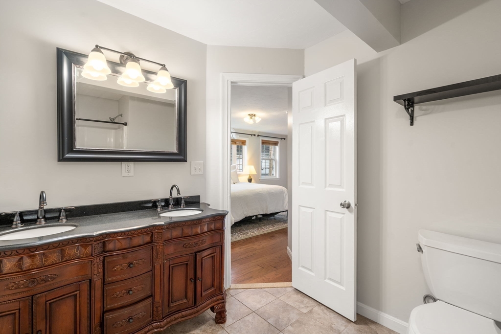 104 Crescent Street, Unit 1 Waltham, MA 02453 - Photo 17 of 30 a en suite bathroom with double sink and a mirror