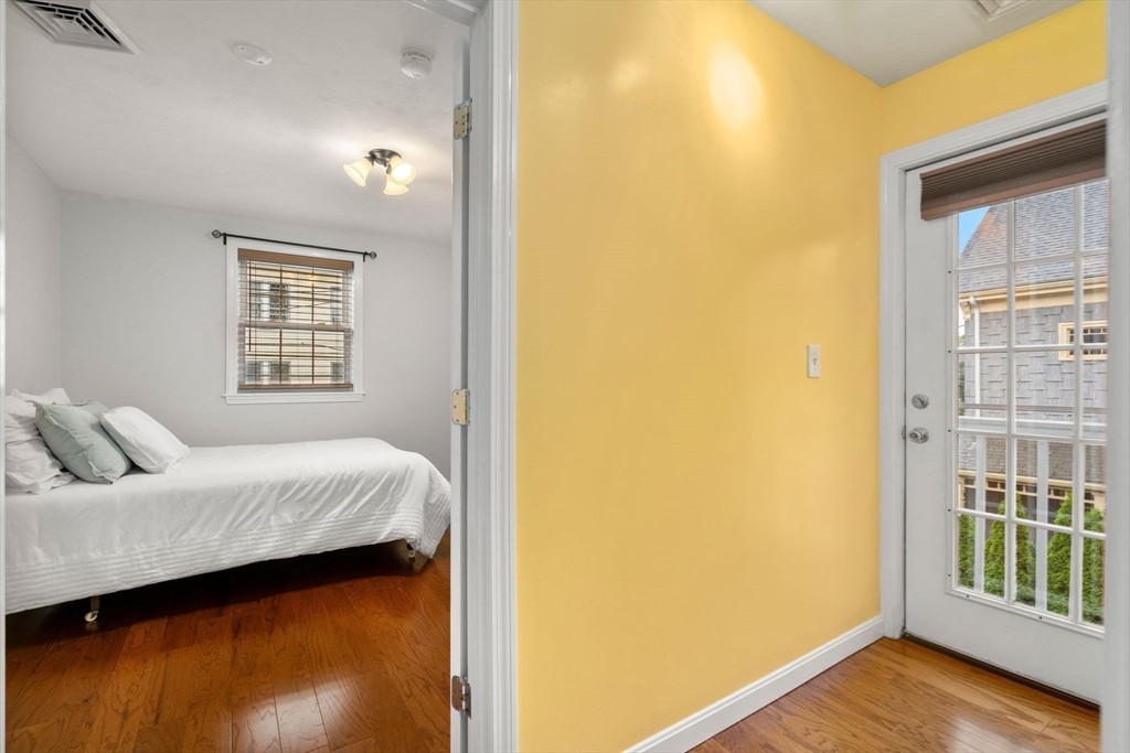 104 Crescent Street, Unit 1 Waltham, MA 02453 - Photo 20 of 30 a bedroom with a bed and wooden floor